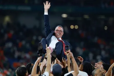 Morocco coach Mohamed Ouahbi is lifted into the air by his players.