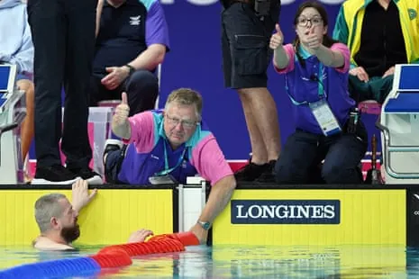 Repairs are made to the lane ropes during the men's 100m breaststroke heats.