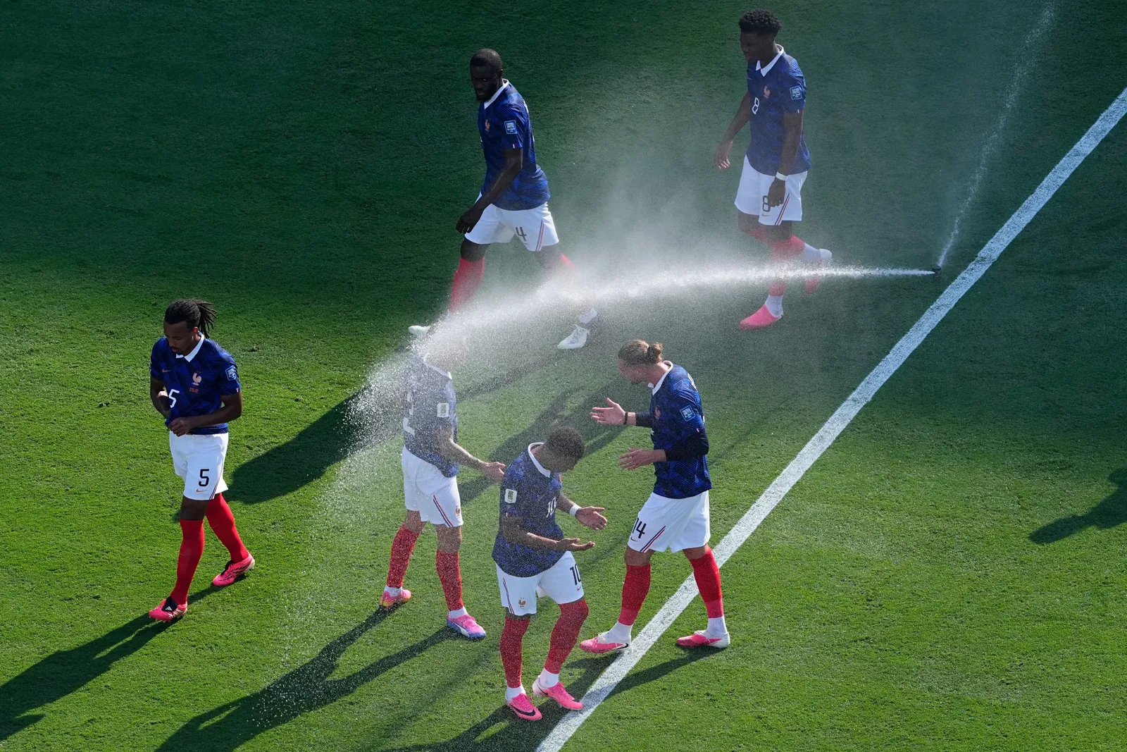 French players cool off from field sprinklers during the World Cup round of 32 soccer match against Sweden in East Rutherford, N.J., near New York, Tuesday, June 30, 2026. (AP Photo/Petr David Josek)