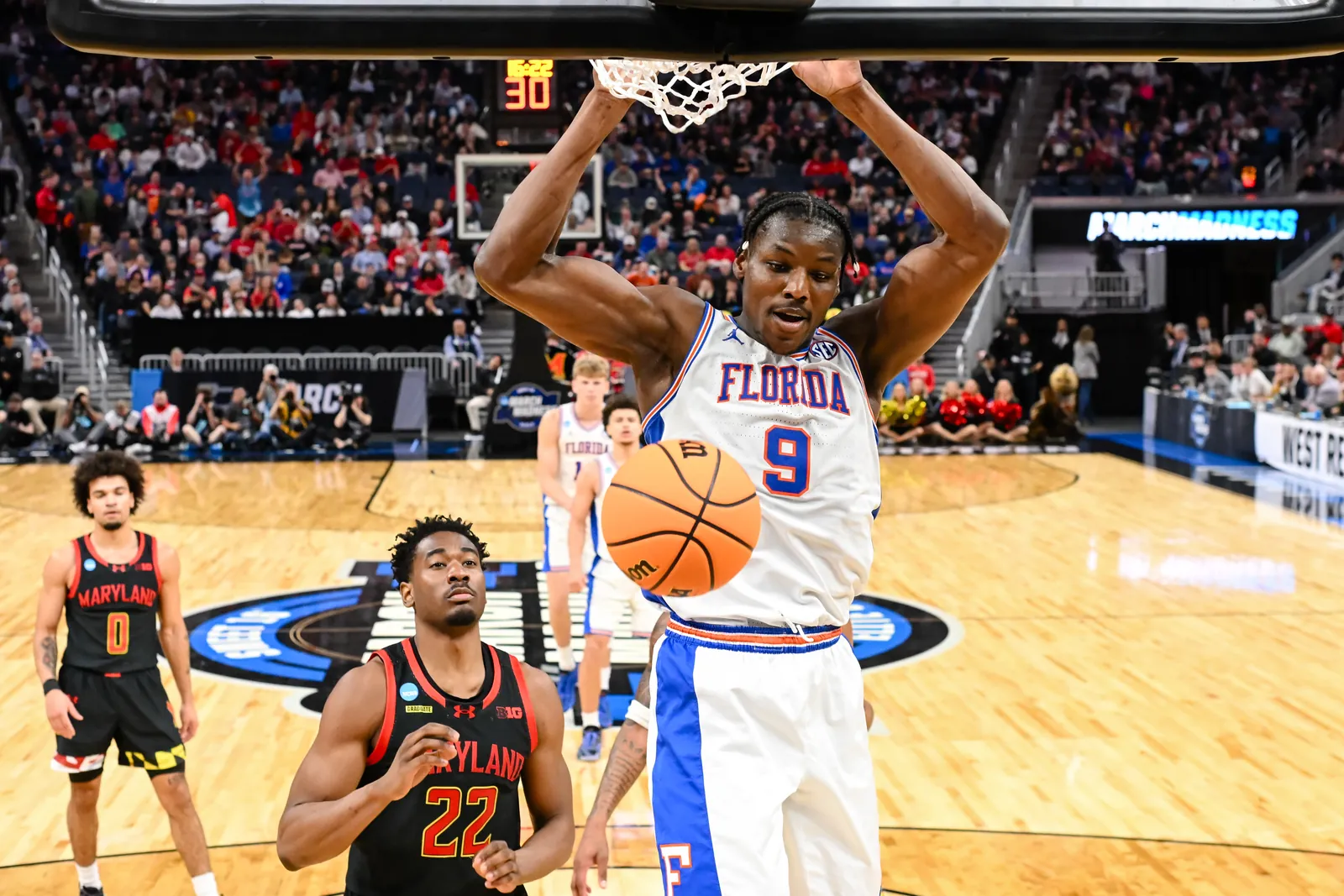 Rueben Chinyelu soars above Maryand defenders for a two-handed dunk