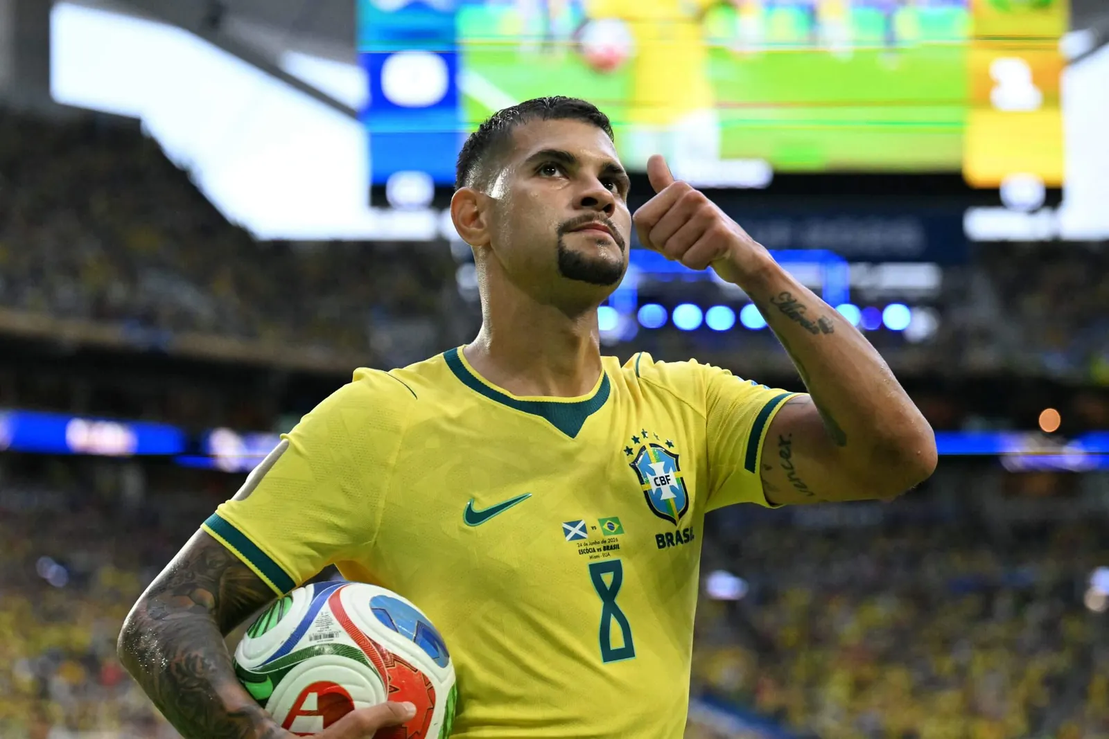 A footballer in a yellow shirt gives a thumbs up